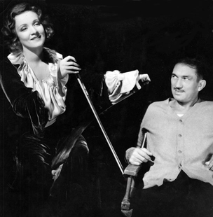 Marlene Dietrich playing the Musical saw - Victor McLaglen listening